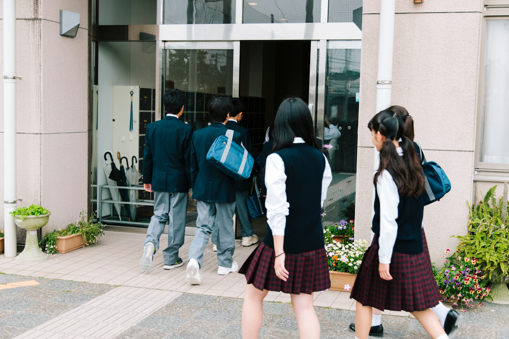 Japanese high school. Young students walk into school, entrance, uniform