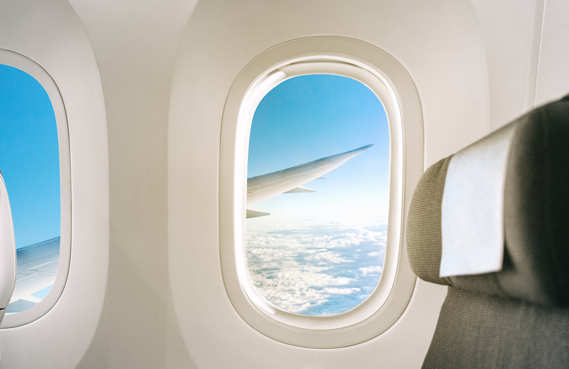 Inside of a Plane Window View of Wing during Flight of Airplane Interior with Seat Background